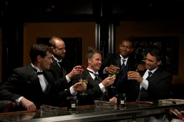 Men in dinner jackets drinking cocktails in bar